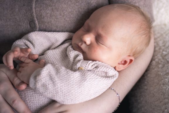 Bebis ligger i mammas famn och sover, inspiration för familjefotografering, Anna Esmelöv