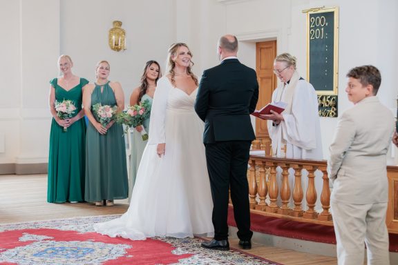 Brudpar utväxlar löften under vigsel i Kuddby kyrka, Vikbolandet porträttfotograf Anna Esmelöv