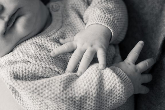 Svartvit detaljbild av ett nyfött barns händer, familjefotograf Anna Esmelöv, Linköping, Östergötland
